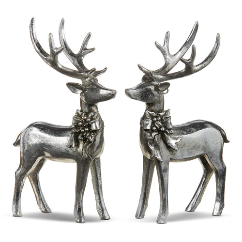 The 7 Set of Two Silver Deer with Bow Ornament (4312130) features metallic reindeer figures facing each other, adorned with neck bows, shiny reflective surfaces, and detailed antlers, creating a dazzling and festive holiday display.