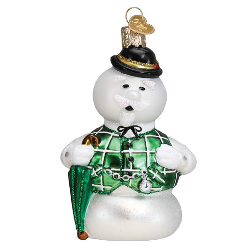 Introducing Sam the Snowman Ornament (Old World Christmas 44207), a charming hand-blown glass decoration. He wears a green plaid waistcoat with black buttons and a bowtie, holds a green umbrella, and dons a black top hat with a gold clover. His cheerful expression, black eyes, and white mustache spread holiday joy!.