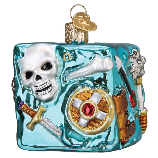 A square, translucent teal Dungeons and Dragons Gelatinous Old World Christmas Ornament 44230 featuring an embedded white skull, a sword, a shield with a red gem, and other adventure gear.