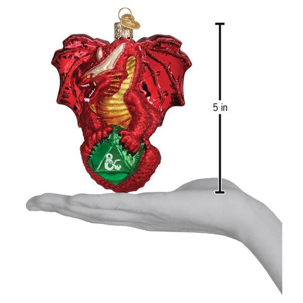 A hand holds a Dungeons and Dragons Red Dragon Old World Christmas Ornament 44231, which is a red dragon clutching a green 20-sided die, shown with a 5-inch measurement to the side.