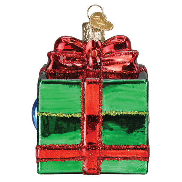 Dungeons and Dragons Holiday Mimic Old World Christmas Ornament 44232 shaped like a green gift box with a red bow, featuring a pair of eyes peeking out from the side.