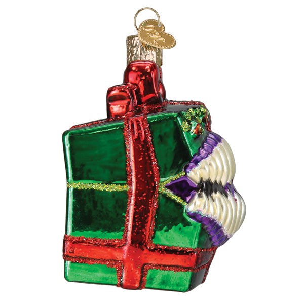 Dungeons and Dragons Holiday Mimic Old World Christmas Ornament 44232, a glass ornament shaped like a green gift box with a red ribbon, featuring a wide mouth with sharp teeth on one side.