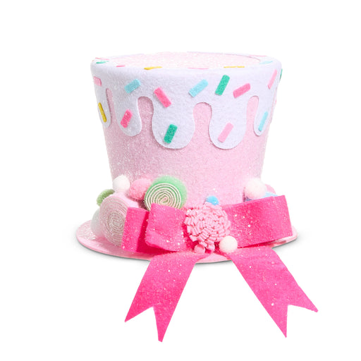 The 8.5" Pink Sprinkles Top Hat 4516558 features polyester construction, white icing, colorful sprinkles, pastel candy accents, and a large pink bow with white pom-poms for a whimsical holiday look.