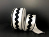 A partially unrolled roll of 1.5X10Y White Black Ribbed Satin Rick Rack Center Ribbon (45353-09-01) with stitched edges against a black background.