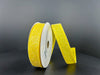 A roll of 7/8X10Y Yellow Candy Glittered Satin Ribbon 46420-05-22 is upright against a dark gray background. One end is unrolled, standing vertically to highlight the sparkly texture.