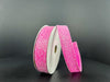 A partially unwound spool of 7/8X10Y Fuchsia Candy Glittered Satin Ribbon (46420-05-28) curls upward, its shimmering surface contrasting against a smooth, dark background.