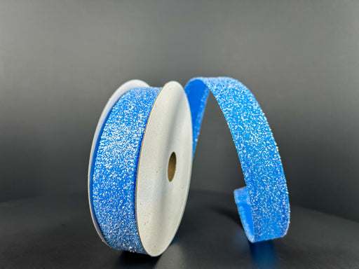 Two spools of 7/8X10Y Turquoise Candy Glittered Satin Ribbon 46420-05-39 are shown on a dark background. One stands upright, the other is unraveled, revealing the glittery texture of the wired satin ribbon.