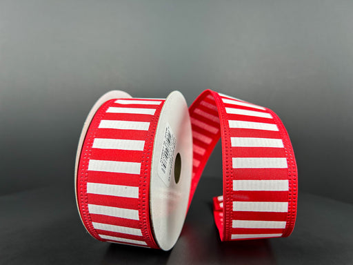 Two spools of Red Satin-White Stripes/Red Edge ribbon (1.5X10Y 46425-09-12) stand against a dark background. One spools ribbon is partially unrolled, creating a flowing effect between them.
