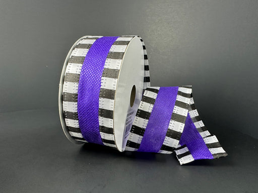 The 1.5X10Y Purple Flat Breeze/Black And White Stripe Edge Ribbon (46521-09-11) is partially unspooled, revealing alternating black and white stripes with a central purple strip, against a dark gray background.