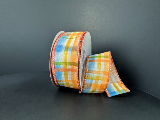 A 1.5x10Y Ivory Linen/Blue-Rust-Yellow-Moss Tuttola Plaid Ribbon (61503-09-05) is displayed against a plain dark background, featuring a colorful plaid pattern with stitched edges.