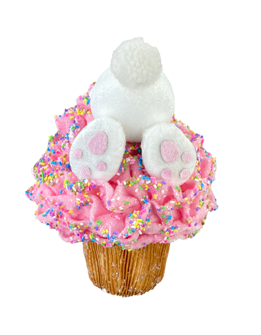 A cupcake features a playful touch with the 8 by 6 Pink Bunny Butt Cupcake Ornament 63281PK, topped with pink icing and colorful sprinkles, resembling a bunny diving into it.