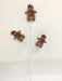 The 29 Long Brown Gingerbread Lady Spray 65252 features three festive gingerbread ladies with red bows and scarves on white wire stems, arranged bouquet-style against a white background—ideal for holiday displays.