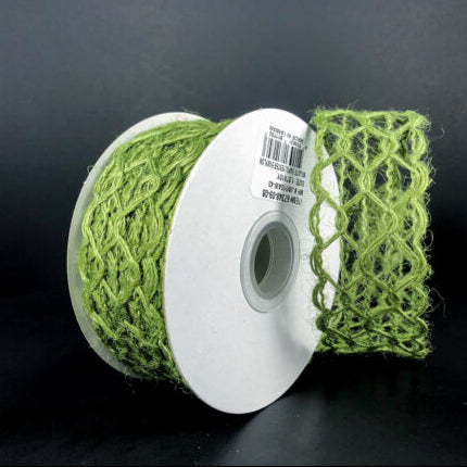 The 1.5X10Y Green Ms Green Scallop Weave Burlap Ribbon (67348-09-08) rests against a dark background, partially unwound to display its net-like scallop weave pattern and fibrous green material.