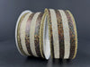 Two rolls of 1.5X10Y Chocolate Natural Gold Woven Metallic Stripe Ribbon (68456-09-38) are shown against a dark background, featuring glittery brown and textured cream stripes with shiny gold-edged borders.