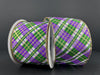 Two upright spools of wired ribbon against a dark background feature the 2.5X10Y White Linen/Emerald-Purple-Gold Busy Plaid 72424-40-01 pattern with gold-trimmed edges and white cores, adding an elegant touch.