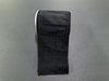 A roll of 4"X10Y Black Faux Dupioni Ribbon (72434-04-21), reminiscent of a sleek black strip, sits on a gray surface.