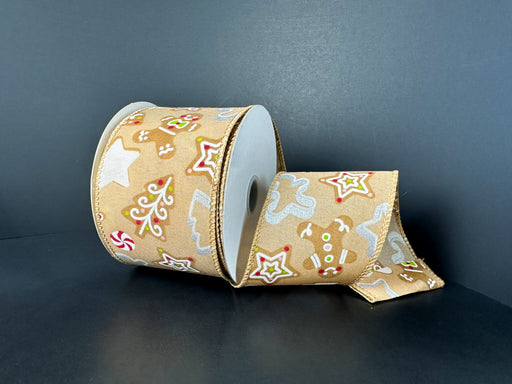 A 2.5X10Y Tan Satin/Gingerbread Cookie Cutout Ribbon (72535-40-14) featuring gingerbread men, Christmas trees, stars, and candy designs in red and white is displayed against a plain dark background.