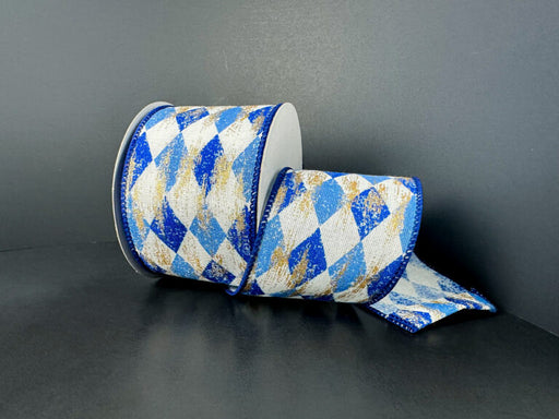 A roll of 2.5x10Y Cream Canvas/Navy-Blue Faded Harlequin/Gold Metallic Ribbon (73523-40-27) is partially unspooled on a dark surface against a dark background.