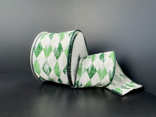 A spool of 2.5X10Y Cream Canvas/Sage-Hunter Faded Harlequin/White Metallic Ribbon (73524-40-06) with a green and white diamond pattern and green edges is partially unrolled against a plain dark background.