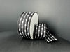 A spool of 1.5X10Y Black/White Snowball Weave Ribbon (73539-09-21), featuring stitched oval shapes and lines in a black and white design on a plain dark background.