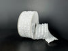 A 1.5X10Y White-Iridescent/White Snowball Weave Ribbon (73540-09-01) with a textured dot pattern is shown against a black background, featuring an unrolled section lying flat.