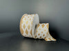 A spool of 1.5X10Y Ivory and Gold Linen/Gold Metallic Diamond Cascade Ribbon (73559-09-15) is partially unrolled, displaying its gold and white diamond pattern against a plain dark background.