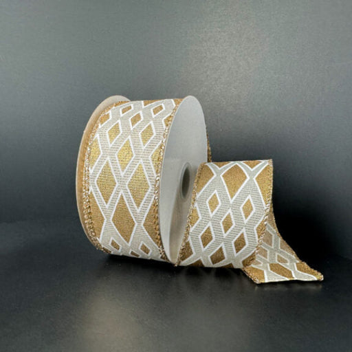 A spool of 1.5X10Y Ivory and Gold Linen/Gold Metallic Diamond Cascade Ribbon (73559-09-15) is partially unrolled, displaying its gold and white diamond pattern against a plain dark background.