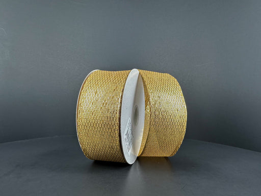 Two rolls of 1.5X10Y Gold Stairstep Woven Metallic Ribbon (76310-09-15) with white centers stand upright on a dark gray background, their glittery metallic stairstep design reflecting the light.