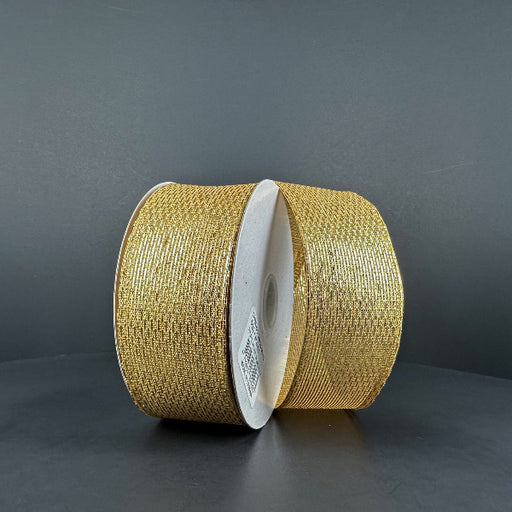 Two rolls of 1.5X10Y Gold Stairstep Woven Metallic Ribbon (76310-09-15) with white centers stand upright on a dark gray background, their glittery metallic stairstep design reflecting the light.