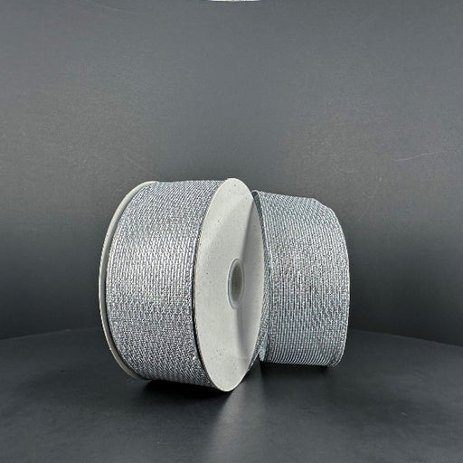 Two spools of 1.5X10Y Silver Stairstep Woven Metallic Ribbon (76310-09-51) sit side by side on a dark, matte surface against a neutral background.