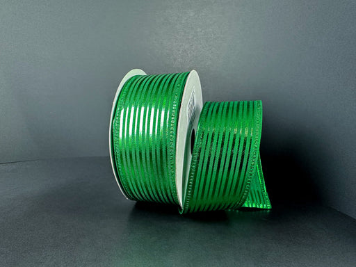 A spool of 1.5X10Y Emerald Satin/Metallic Embossed Vertical Grain Ribbon (76555-09-17) with horizontal black stripes stands upright on a dark surface, some ribbon unrolled nearby, set against a plain gray background.