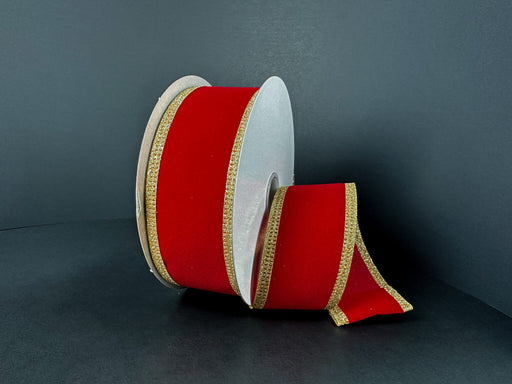 A partially unrolled 1.5X10Y Red Velvet/Gold Glitter Edge Ribbon (76561-09-15) is displayed against a dark background, showing its red velvet material and sparkling gold glitter trim.