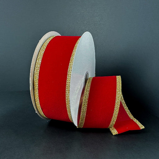 A partially unrolled 1.5X10Y Red Velvet/Gold Glitter Edge Ribbon (76561-09-15) is displayed against a dark background, showing its red velvet material and sparkling gold glitter trim.