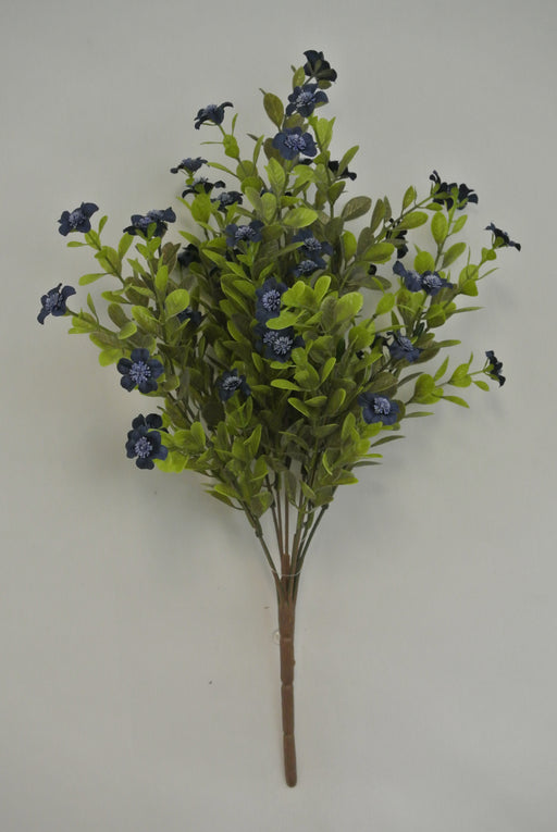 The 16 Blue Filler Bush 9 Stems 85152-BL features artificial green leaves and small dark blue flowers on brown stems, set against a plain light gray background.