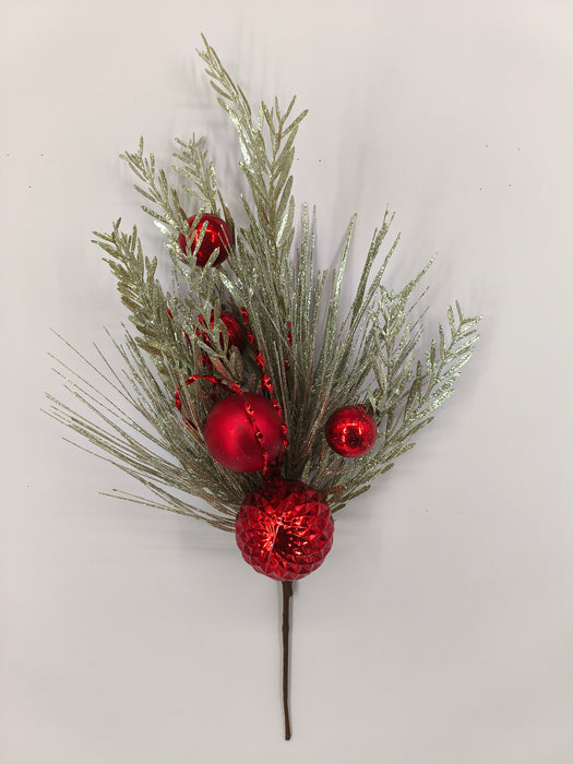 The 24" Red Needle Pine Plastic Leaf Spray 85154-RD features glittery silver pine branches, shiny red ornaments, and textured baubles—all arranged on a plain white background for a festive Christmas display.