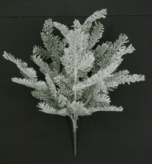 The 20" Snowed Pine Bush with 6 Stems (85287) features white-tipped artificial pine greenery and small pine cones, beautifully displayed against a plain black background.