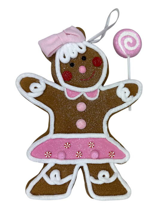The H10xW8.5xD1.5 Brown and Pink Gingerbread Girl Ornament 86498BNPK features white icing details, a pink bow and skirt with buttons, a happy expression, holds a pink swirl lollipop, and includes a loop for easy hanging.