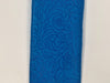 Close-up of the 2.5X10Y Turquoise Flower Embossed Ribbon (984240-39) features intricate turquoise leather with embossed floral patterns, including swirls and leaf-like shapes, adding texture and elegance.