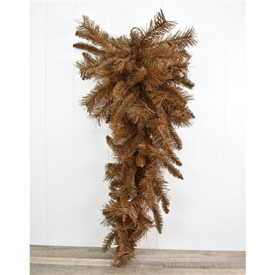 The 30 Brown Mixed Pine Teardrop with 90 Ties (DC30TDBR) features dense, downward-hanging branches and is beautifully displayed against a white wall and wooden floor.