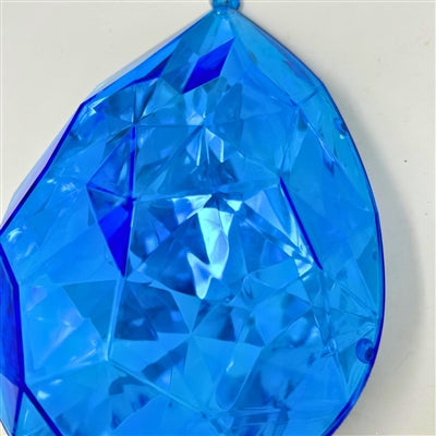 A close-up of the 6.3" x 4" x 9" Dark Blue Plastic Drop Ornament DCORN5408DKBL shows its faceted surface reflecting light and revealing geometric patterns against a plain white background.