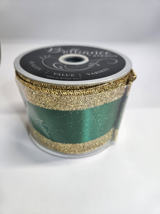 A spool of 2.5x10yd Emerald Gold Vertical Glitter Stripe Ribbon (LS31207R) labeled “Brilliance” sits on a white surface, its sparkling stripes adding elegance and shimmer to any décor.