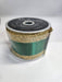 A spool of 2.5x10yd Emerald Gold Vertical Glitter Stripe Ribbon (LS31207R) labeled “Brilliance” sits on a white surface, its sparkling stripes adding elegance and shimmer to any décor.