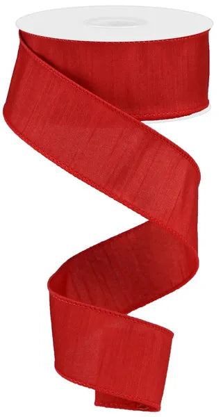 A spool of Red Faux Dupioni Ribbon 1.5 Inches by 10 Yards (RD110124) is unfurled in a loose spiral on a white background, showcasing its sheer and slightly shiny texture.