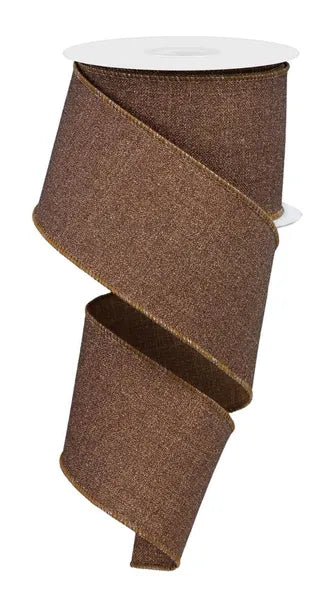 A 2.5x10yd brown ribbon (RGE138104) with fine glitter, gold-edged trim, and a finely textured surface is partially unrolled from a white spool in a loose spiral.
