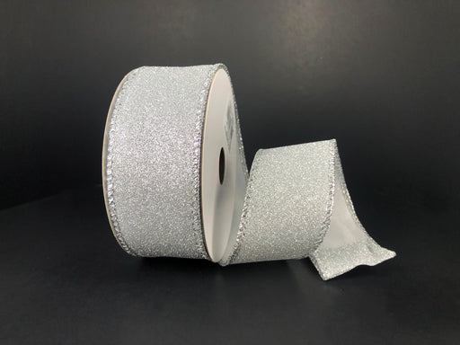 A partially unspooled roll of 1.5X10Y Silver All Flat Glitter Ribbon (X820609-16) with decorative edge is displayed against a plain black background.