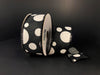 A spool of Black Linen/White Big-Small Dots ribbon, 1.5X10Y, artfully unrolled against a dark background.