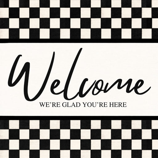 Black and white check Welcome metal sign with We’re Glad You’re Here lettering.
