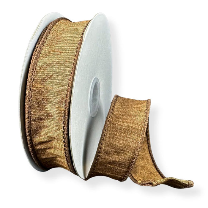 A spool of 7/8" Brown Faux Dupioni Wired Ribbon (10 Yards, 72434-05-38) with a ruffled edge is partially unrolled and displayed against a white background. This elegant ribbon is ideal for craft projects and decorative accents.