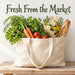 Flat metal sign featuring Fresh From the Market lettering above a natural canvas tote filled with carrots, lettuce, tomatoes, fresh herbs, a rustic baguette, and a bouquet of white daisies and yellow flowers. Neutral textured background with a rustic wooden tabletop. TTE-854.