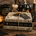 TTE-474 Halloween cookbook stack metal sign featuring whimsical recipe books, candlelight, apothecary bottles, pumpkins, witch-themed kitchen décor, and vintage Halloween accents.